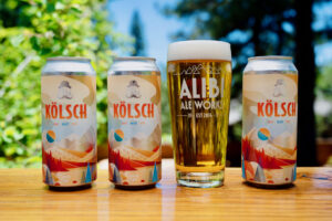 cans and pint of Alibi Kolsch outside in the beer garden