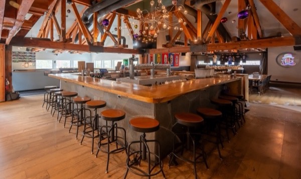Alibi Ale Works Incline Village taproom with a distinctive chandelier, wood beams and central bar