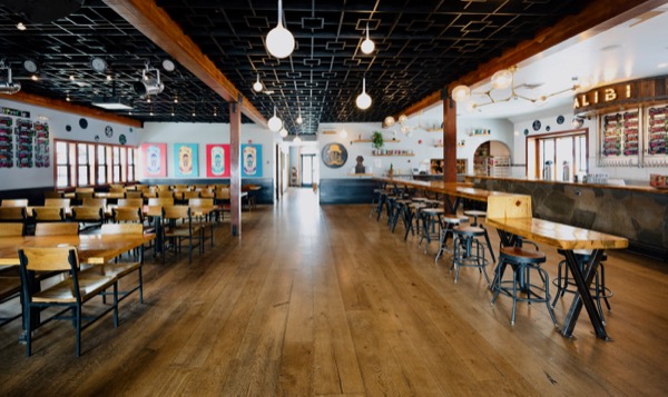 Alibi Ale Works Truckee taproom with dining tables, beer taps and illuminated Alibi sign